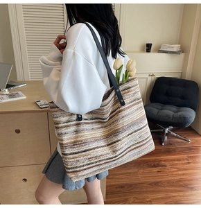 Detail of colorful striped woven tote bag with premium black leather shoulder straps