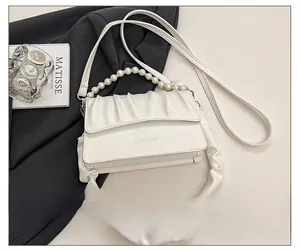 Detail view of white ruched cloud bag featuring pearl chain and fashion lettering print