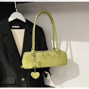 Vue détaillée du sac porté épaule vert citron avec texture croco, pendentif cœur et nœud