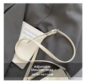 Detail showing an adjustable cream faux leather shoulder strap with silver buckle