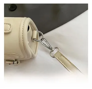 Macro detail of high-quality silver metal swivel hook and strap on white leather bag