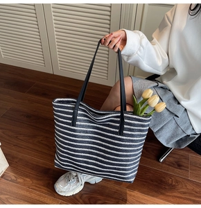 Close-up of large blue and white striped tote bag with black leather straps and tulips