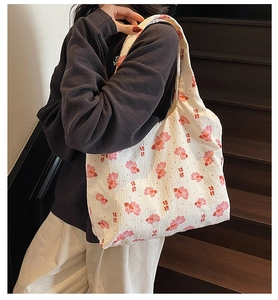 Close-up of canvas tote bag with pink koi fish patterns shown on model's shoulder