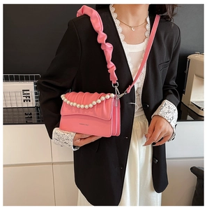 Pink pleated cloud bag with elegant pearl chain strap shown on professional model