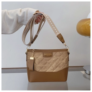 Detailed close-up of khaki quilted bucket bag with wide jacquard strap and leather trim