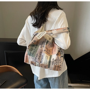 Detail view of cotton tote bag with vintage Chinese calligraphy print on model shoulder