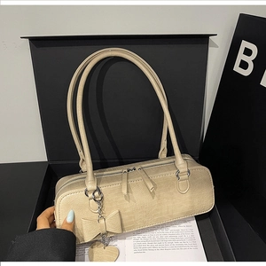 Détail du sac baguette beige gaufré crocodile avec nœud décoratif en coffret cadeau