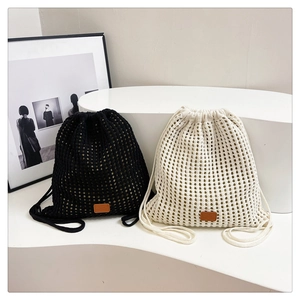Detail of woven mesh drawstring backpack showing cream knit texture and leather brand tag