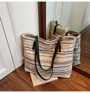 Detail of multi-color woven striped tote bag showing fiber texture and long handles