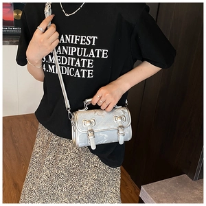Silver metallic cylinder crossbody bag featuring mirror-finish synthetic leather and buckles