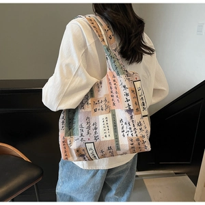 Close-up of artistic floral canvas tote bag showing textured fabric and wide shoulder strap