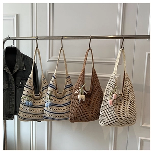 Detailed view of handmade hollow crochet tote bags in various colors on display hooks