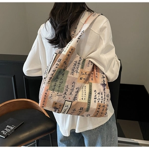 Detail of canvas tote bag showing artistic calligraphy print and colorful pattern textures