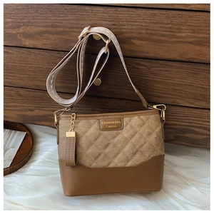 Detail of a brown bucket bag with quilted suede, smooth leather and geometric strap