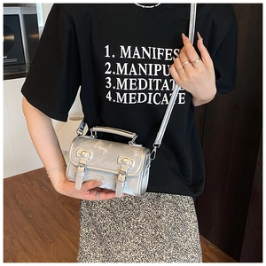 Detail of silver mini crossbody bag featuring dual bow accents and metallic texture