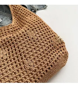 Detail of hand-woven hollow pattern and durable texture on brown straw tote bag