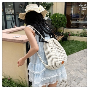 Detailed knit pattern on white drawstring bucket backpack in boho crochet style