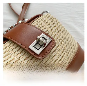 Macro shot of silver metal square lock and straw woven texture on a chain shell bag