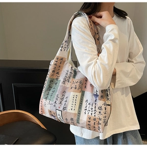 Close-up of canvas tote bag featuring artistic Chinese calligraphy and patchwork design