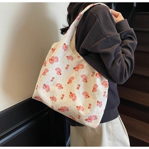 Detail of white tote bag with red koi fish print and waffle texture on shoulder