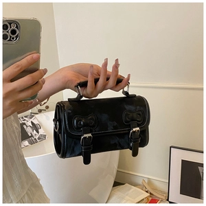 Mirror selfie showing a black vintage style small square bag with decorative metal buckles