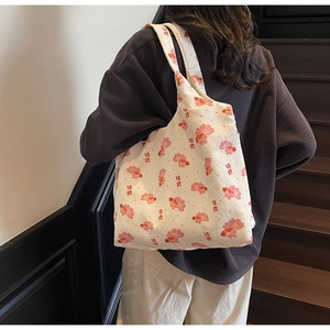 Detail of white canvas tote bag featuring pink koi fish patterns and artistic calligraphy