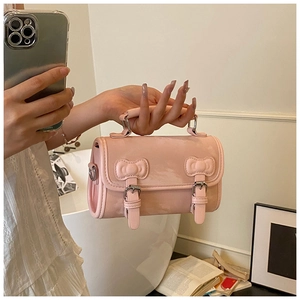 Detail of pink PU leather square bag featuring sweet bow buckles and round top handle