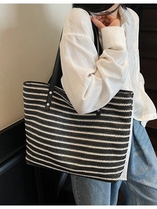 Handmade black and white striped woven straw tote bag with black leather shoulder straps