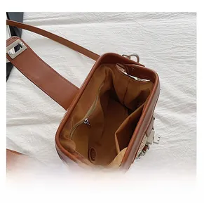 Internal layout of brown leather crossbody bag with zipper pocket and metal lock