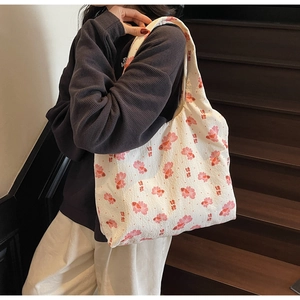 Close-up of white tote bag featuring red koi fish patterns and Chinese calligraphy