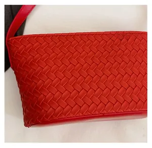 Detailed view of red hand-woven Intrecciato leather texture and matching shoulder strap