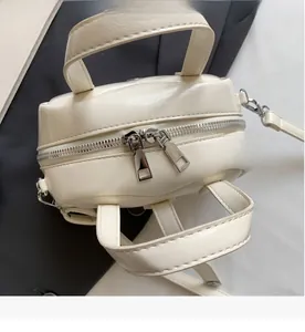 Detail view of smooth double metal zippers and premium cream PU leather pillow bag