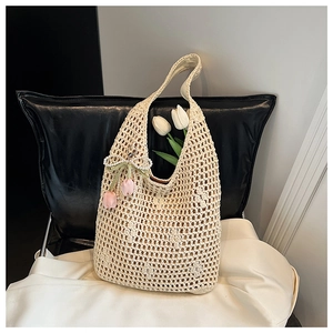Detailed close-up of handmade cream hollow-out woven tote bag with tulip floral charm
