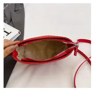 Macro view of red woven shoulder bag interior with beige lining and side pocket