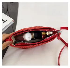 Top view of red woven shoulder bag showing spacious interior with cosmetic items