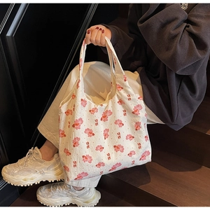 Detail of white tote bag featuring pink koi fish print and textured bubble fabric