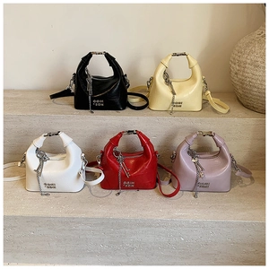 Group of colorful mini handbags in crocodile texture displayed on stone stairs