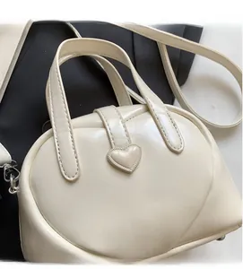 Close-up of white heart-shaped handbag featuring smooth PU leather and a 3D heart clasp