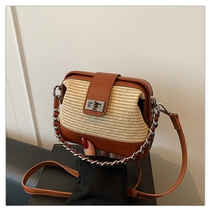 Detail of woven straw and brown leather crossbody bag with silver twist lock and chain strap