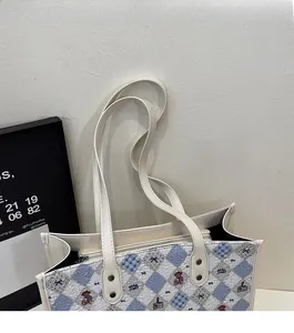 Détail du grand sac cabas blanc avec motif d'ours, losanges bleus et fines anses souples
