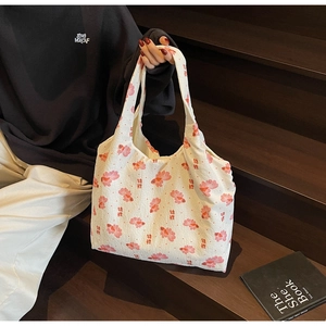 Close-up of white canvas tote bag with pink goldfish prints and textured fabric detail