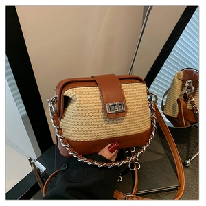 Detail of woven straw handbag with brown leather trim and metallic rotary lock hardware