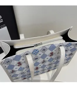 Détail de la fermeture éclair argentée et texture matelassée du sac cabas à motif d'ours