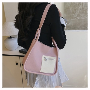 Close-up of pink and white lychee texture leather shoulder bag shown in an interior scene