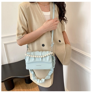 Detail of light blue pleated cloud bag with faux pearl chain and leather shoulder strap