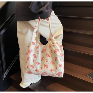 Detail of canvas tote bag featuring pink koi fish print and elegant red typography