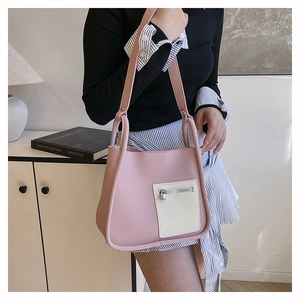 Close-up of pink and cream litchi texture shoulder bag with front zipper pocket