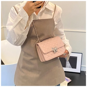 Vue détaillée du sac rose matelassé avec fermoir métallique en forme de nœud argenté