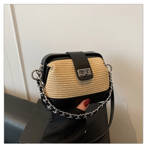 Detail of straw and leather patchwork crossbody bag featuring a silver metal twist lock
