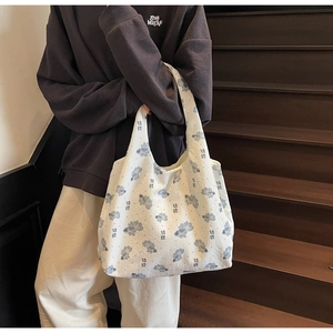 Detail of white canvas tote bag featuring traditional koi fish print and artistic texture